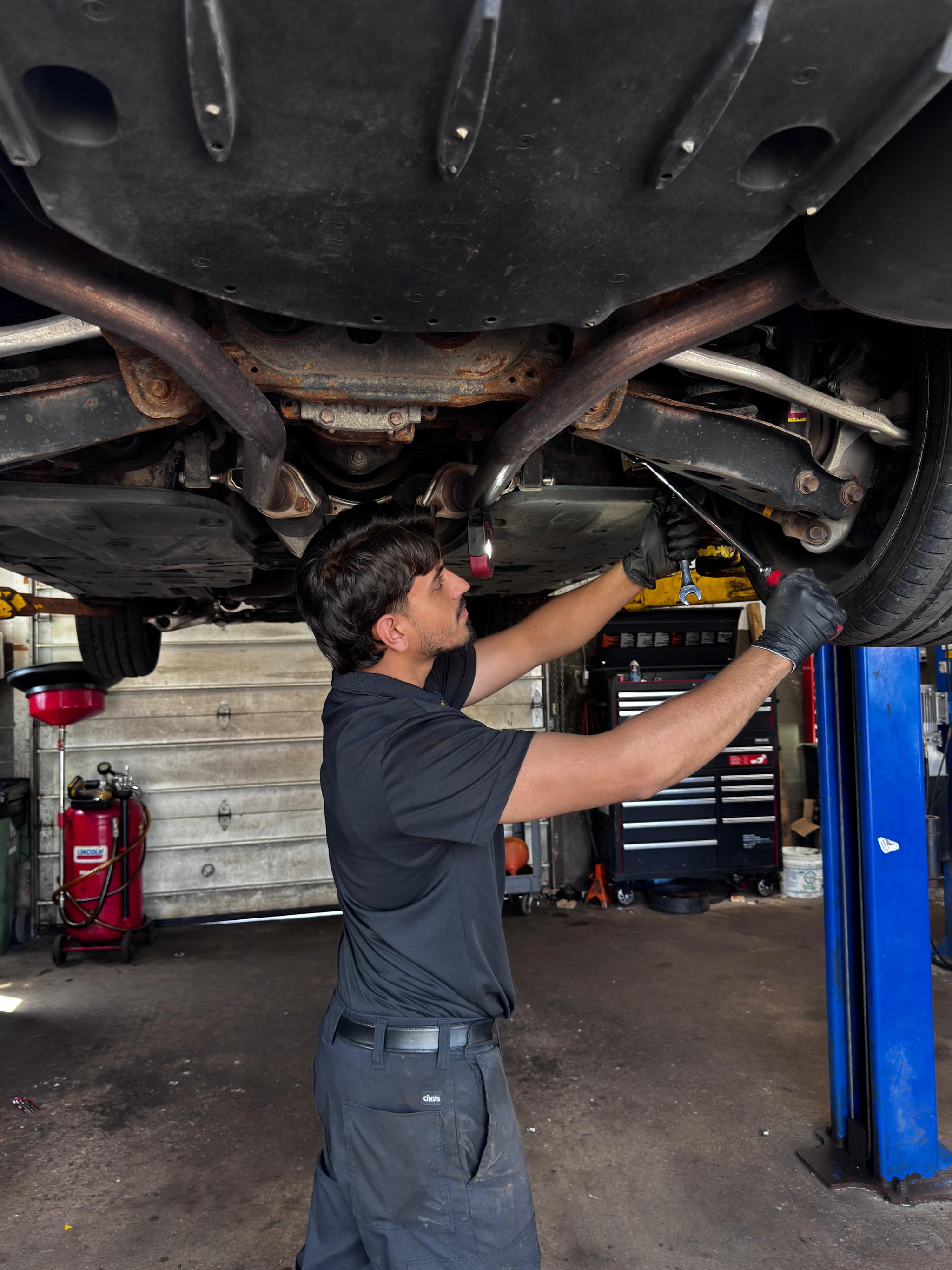 Faizan Qureshi performing professional steering and suspension service under vehicle lift