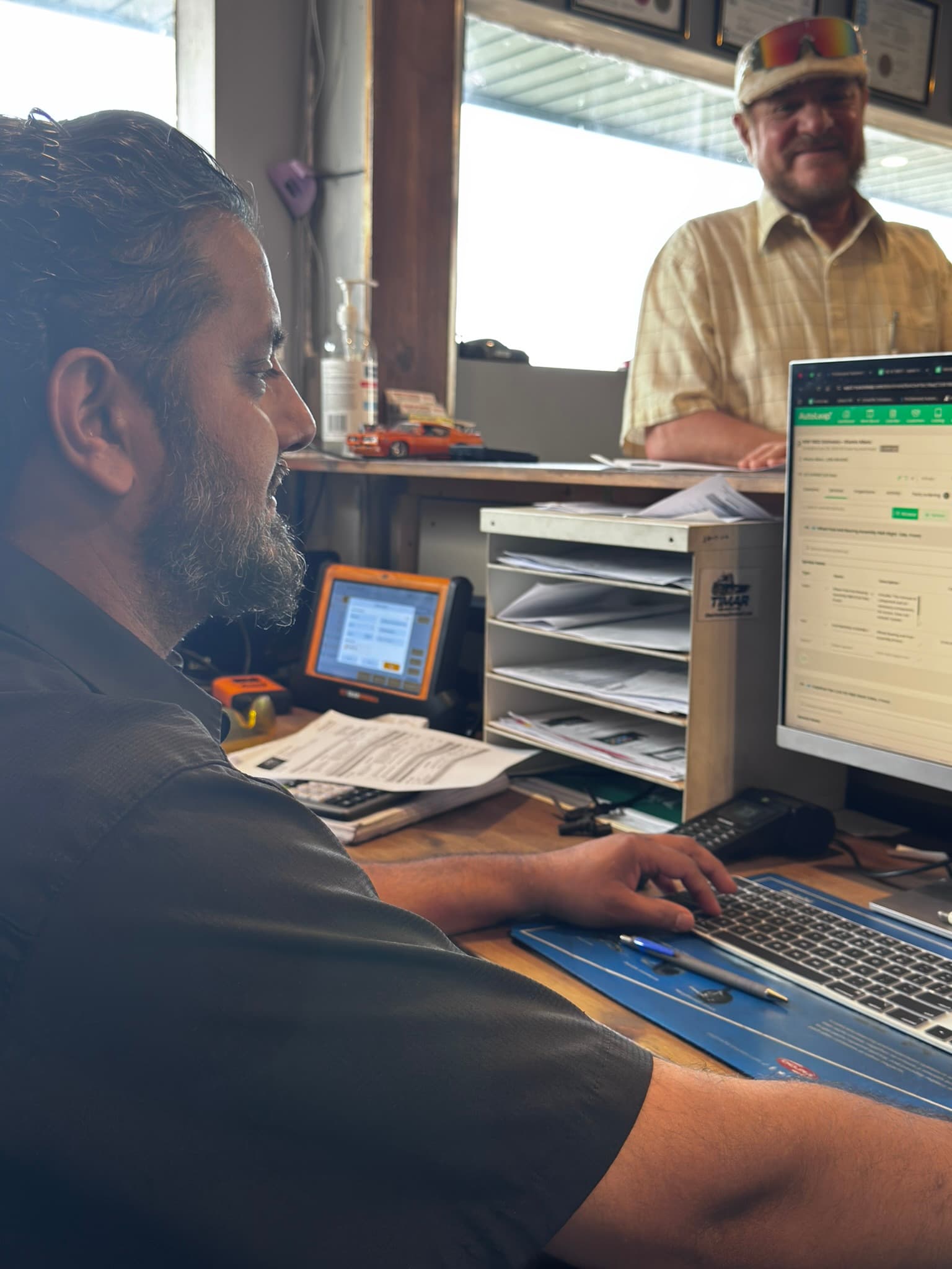 Service advisor guiding the customer stands across the counter