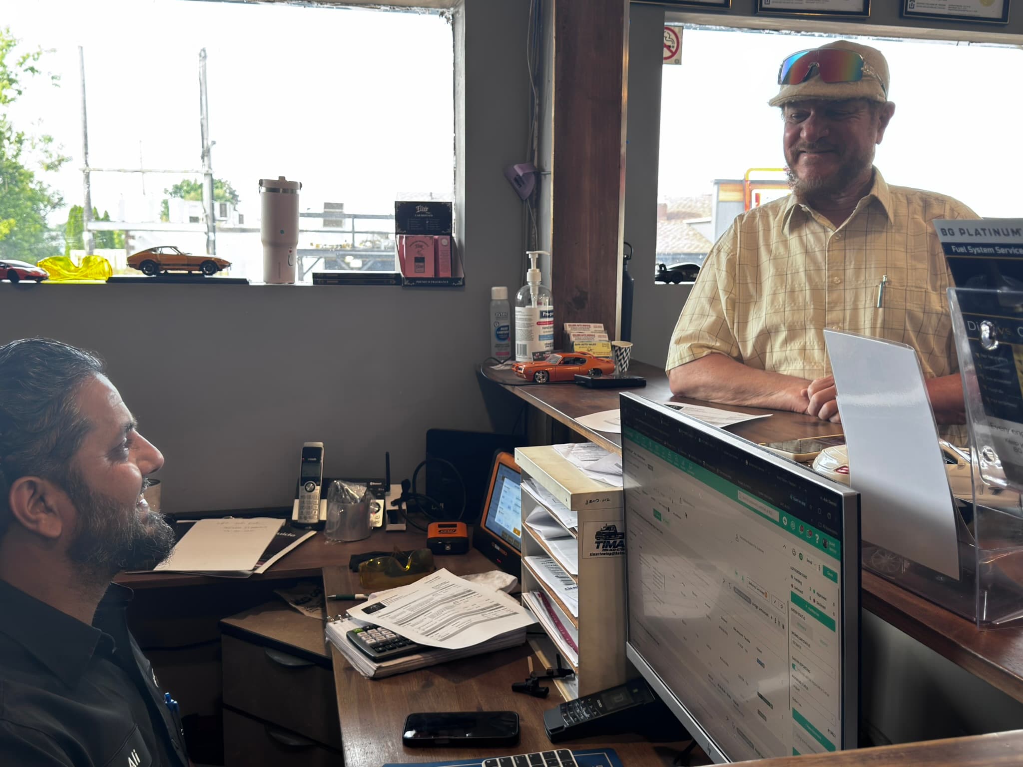 Service employee smiling and talking with a customer across his office desk